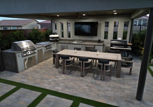 A large outdoor kitchen with an entertainment center.